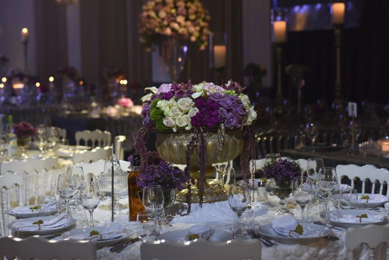 עיצוב שולחנות יוקרתי עם פרחים ואווירה חגיגית באולם אירועים לחתונה או בת מצווה.