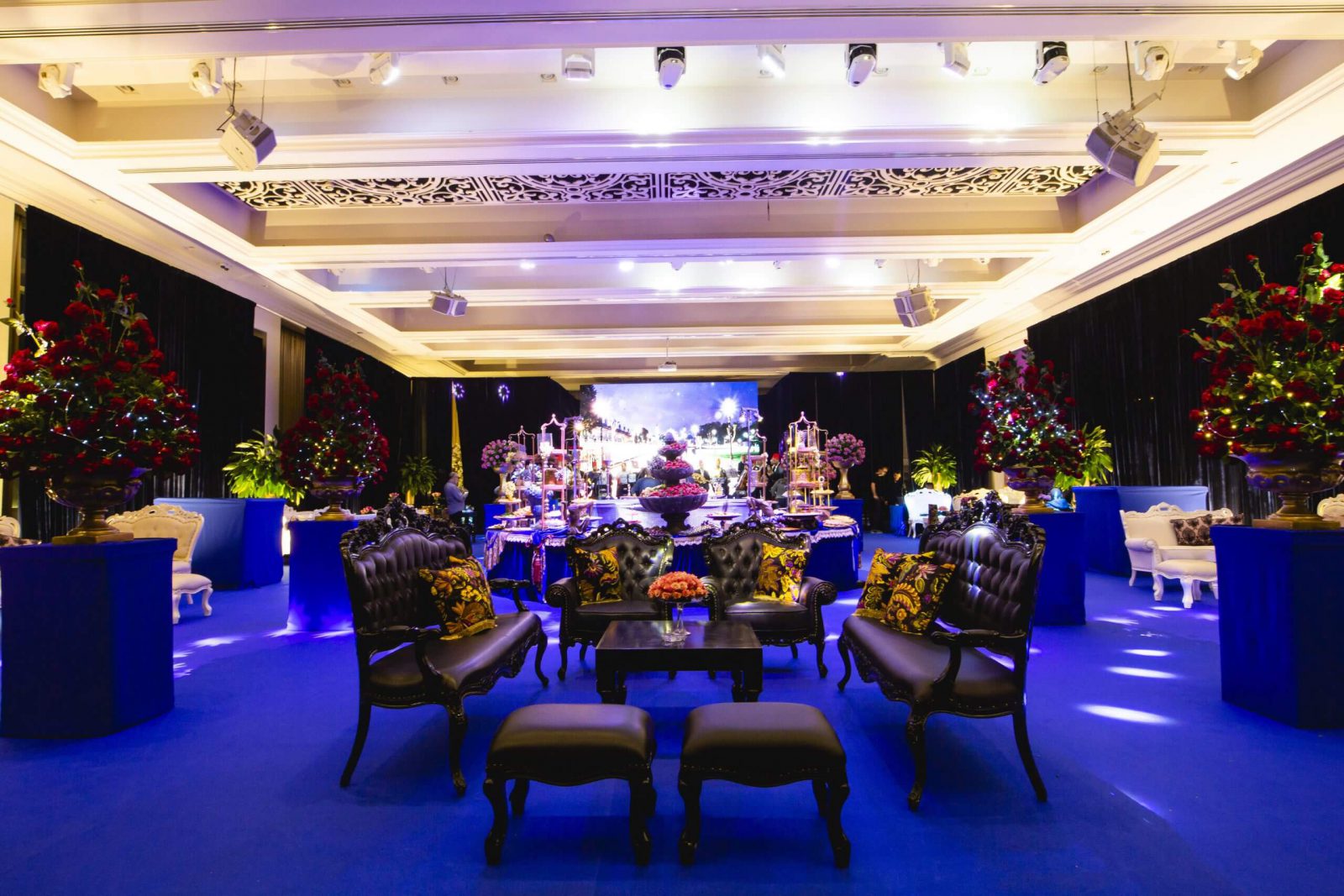 אולם אירועים יוקרתי מעוצב עם ספות, שולחנות ופרחים לאירועים כמו חתונה ובת מצווה.