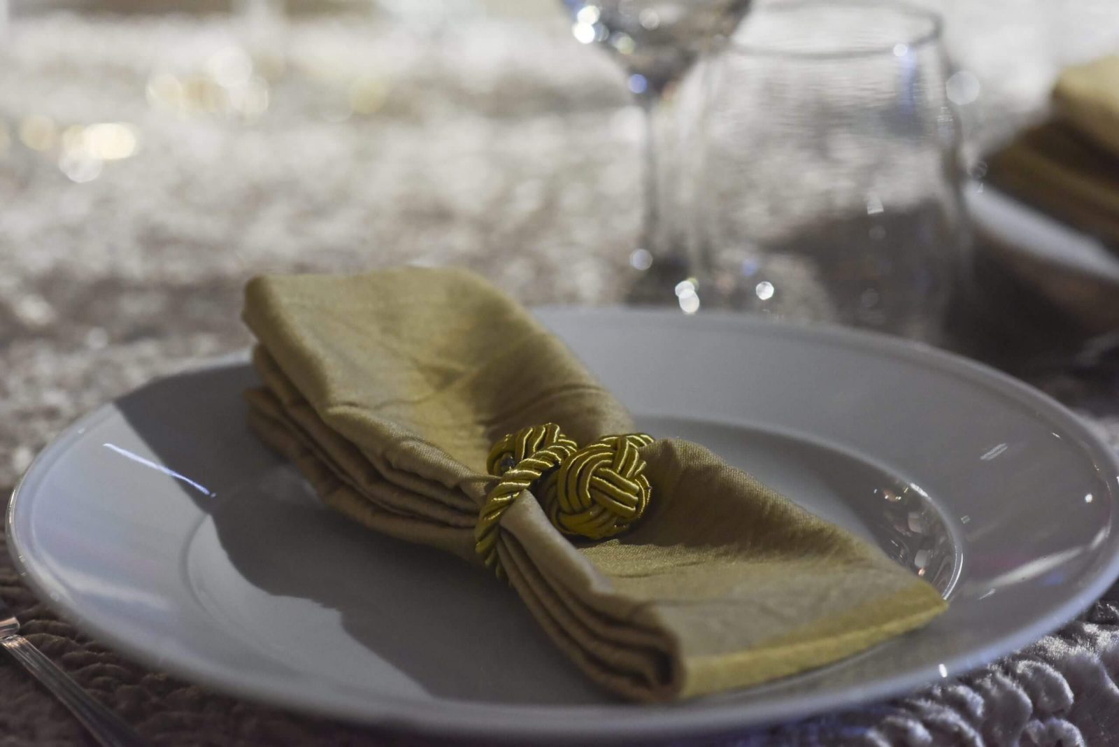 עיצוב שולחן לאירועים, כולל מפית מקופלת עם קישוט, מתאים לאולמות אירועים יוקרתיים.