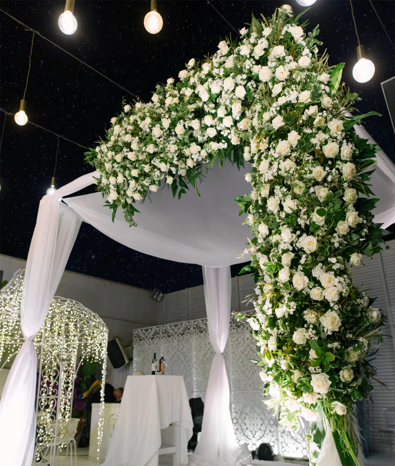 חופה מעוצבת בפרחים לבנים, מושלמת לאירועים כמו חתונות וחתונות יוקרתיות.