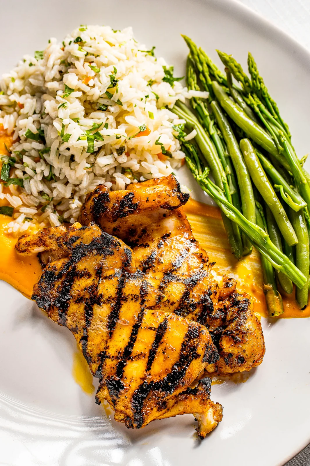 צלחת עם עוף בגריל, אורז עם ירקות ואספרגוס בצד, מנות מגוונות לאירועים קטנים.